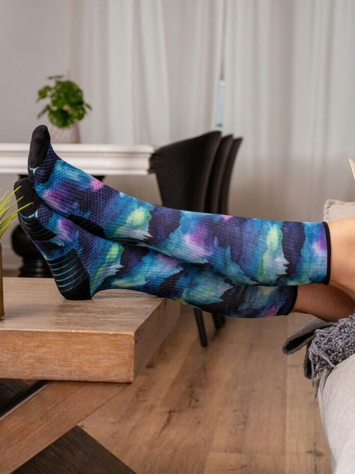 Patterned Compression socks worn with feet up on a table