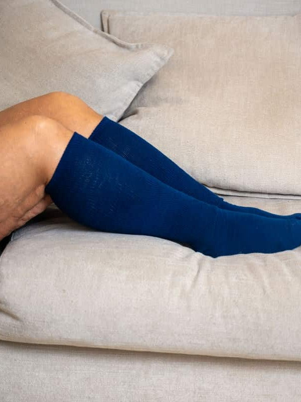 Navy EasyStretch™ socks worn on a sofa
