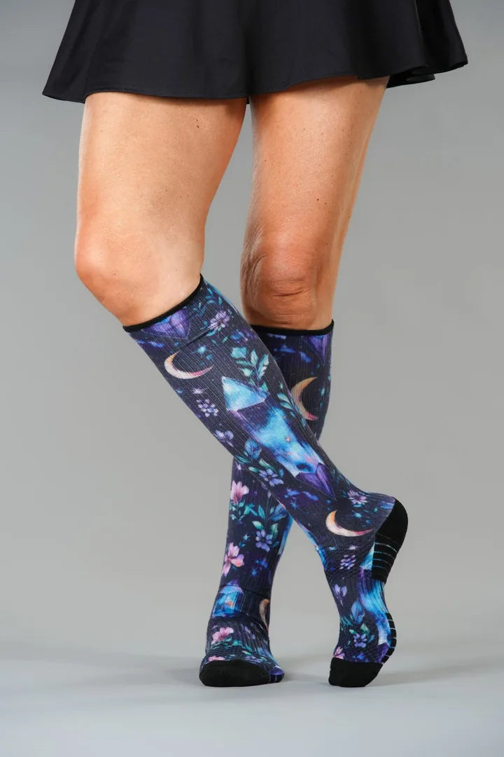 Crystals Compression socks worn standing, legs crossed, ending just below the knee