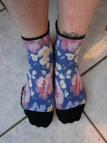 Blue floral Ankle Compression socks worn standing on a tile floor