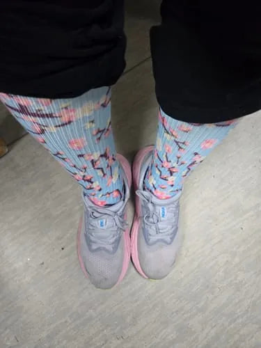 Pale blue floral Compression socks worn standing in sneakers