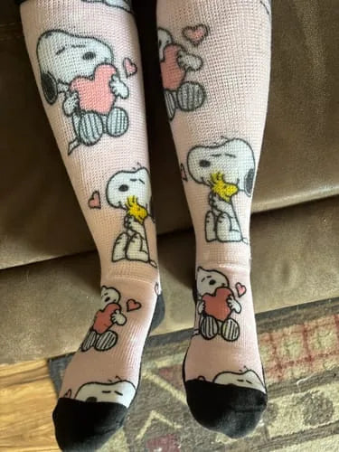Pink cartoon-pattern EasyStretch™ socks worn standing at home