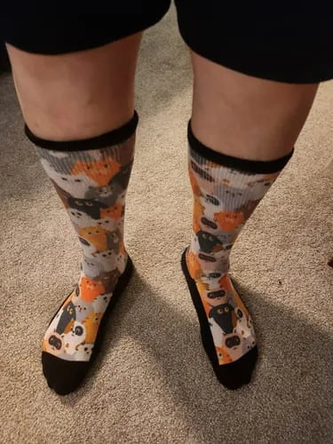 Orange cat-pattern EasyStretch™ socks worn standing