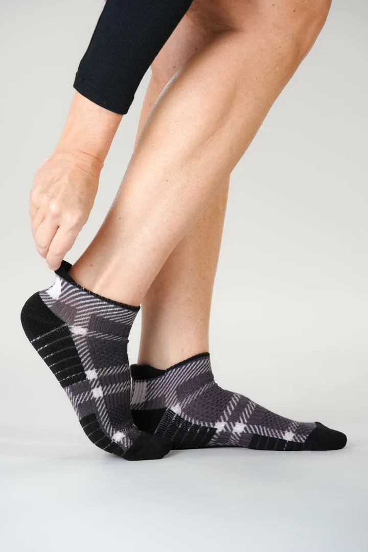 Chocolate Plaid Ankle Compression socks, one hand at the heel tab